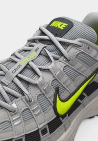 Γκρι παπούτσι Nike με νέον κίτρινο λογότυπο swoosh και ετικέτα «Boneway Series» σε υφασμάτινο επάνω μέρος με υφή και ανακλαστικά κορδόνια.