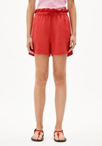 Shorts légers rouges avec une taille élastique et un cordon de serrage. Texture lisse avec une coupe décontractée et des poches latérales.