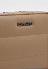 Calvin Klein LINE QUILT MEDIUM ZIP AROUND - Peněženka - chanterelle
