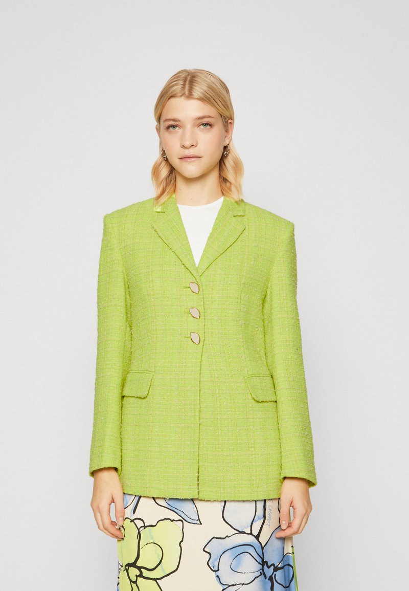 Groene tweed blazer met een gestructureerd ontwerp, twee voorzakken en een sluiting met vier knopen. Geweven stof met een licht glanzende afwerking.