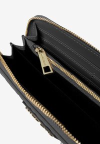 Portafoglio in pelle nera con zip e hardware dorati. Dotato di più slot per carte e di un ampio spazio interno. L'esterno testurizzato aggiunge dettagli.