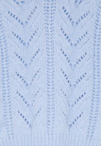 Tissu tricoté bleu clair avec un motif en chevrons, présentant de petites mailles ajourées qui créent une texture et une apparence douce.