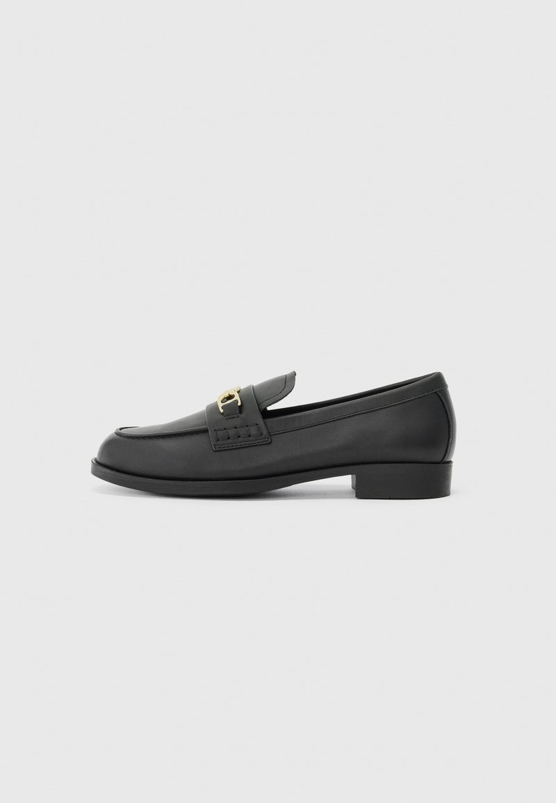 Mocassins de couro preto com bico arredondado, salto baixo bloco e detalhe decorativo em metal dourado. Textura suave com design minimalista.