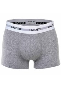 Szare bawełniane bokserki z białym elastycznym pasem z logo Lacoste w kolorze czarnym. Zaprojektowane z dopasowanym krojem i wspierającą kieszonką z przodu.