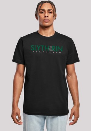 Svart bomullst-skjorte med grønn "SLYTHERIN" tekst og logo-design. Korte ermer, rund hals, normal passform, ingen synlige mønstre eller aksenter.