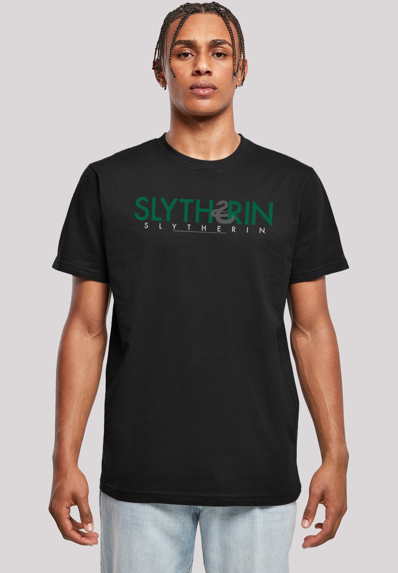 Svart bomullst-skjorte med grønn "SLYTHERIN" tekst og logo-design. Korte ermer, rund hals, normal passform, ingen synlige mønstre eller aksenter.