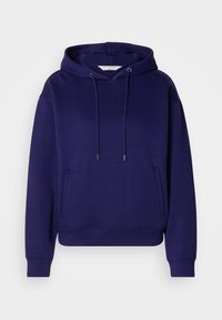 Námornícky modrá mikina s kapucňou, s brúsenou textúrou, predný klokanie vrecko a kovové prevleky na šnúrku. Jemný logotyp na hrudi.
