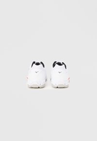 Λευκά αθλητικά παπούτσια με μαύρες λεπτομέρειες, υφή υλικού, στρογγυλεμένο σχέδιο και κόκκινη λεπτομέρεια λογότυπου στη φτέρνα. Ελαστική σόλα για πρόσφυση.