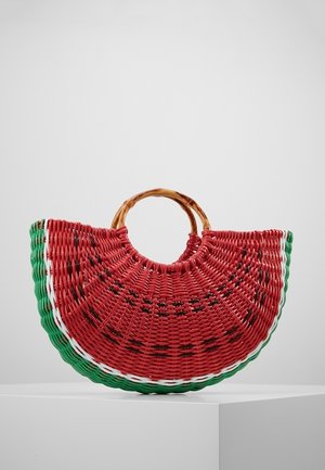 Bolso tejido con forma y colores de una rodaja de sandía, con secciones en rojo, verde, blanco y negro, y asas redondas de madera.