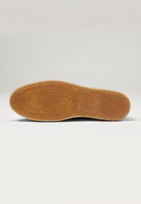 Suela de zapato de goma con un patrón de tracción en波, de color marrón claro y textura pronunciada. Muestra la talla "42" con un detalle de marca.