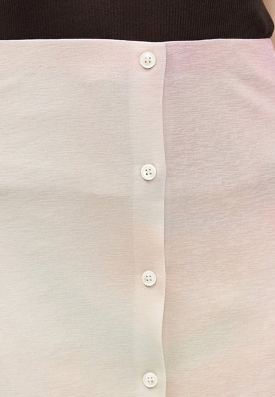 Κατακόρυφη σειρά πέντε λευκών κουμπιών πάνω σε απαλό ροζ και μπεζ ύφασμα, με πιο σκούρο ύφασμα ορατό στην πάνω άκρη.