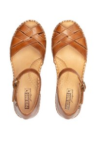 Sandales en cuir marron avec un design à lanières croisées, une lanière de cheville et une semelle intérieure rembourrée. Présente des détails perforés et un bord tressé.