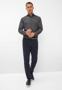 Mannen broek in marineblauw, gecombineerd met een marineblauwe overhemd met stippenpatroon. Heeft een kraagdesign en gestructureerde stof. Klassieke sneakers maken de look compleet.
