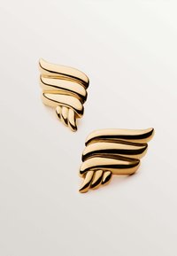 Pendientes en tono dorado con forma de alas, diseño ondulado y superficie texturizada. Presenta acentos en capas y un acabado pulido.