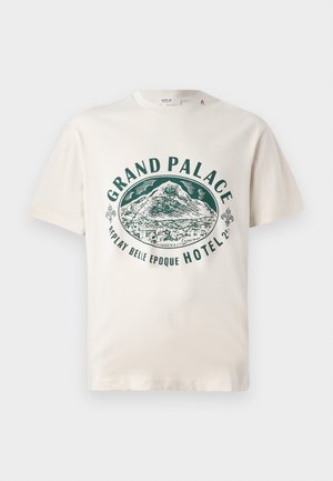 T-shirt in cotone color crema con stampa grafica verde di una montagna e testo che recita "GRAND PALACE REPLAY BELLE EPOQUE HOTEL." Maniche corte.