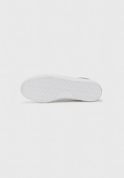 White rubber shoe sole featuring a textured, dotted pattern with subtle branding detail near the heel. Clean and minimalistic design.