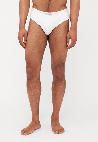Culottes en coton blanc avec une taille logo, design ajusté, texture lisse et style minimaliste. Convient pour un usage quotidien.
