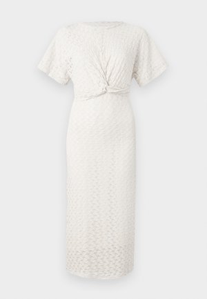 Trikó, krém színű ruha kerek nyakkivágással, rövid ujjakkal és megkötött derékrésszel; a minta domború, texturált elemeket tartalmaz.