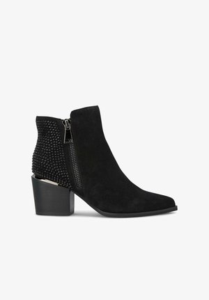 Botines negros de ante con un patrón de cuentas texturizado en el tacón, cremallera lateral y un tacón cuadrado para mayor estabilidad.