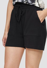 Shorts en mélange de coton noir avec une taille élastique, un cordon de serrage et deux poches latérales dotées de détails de couture subtils.
