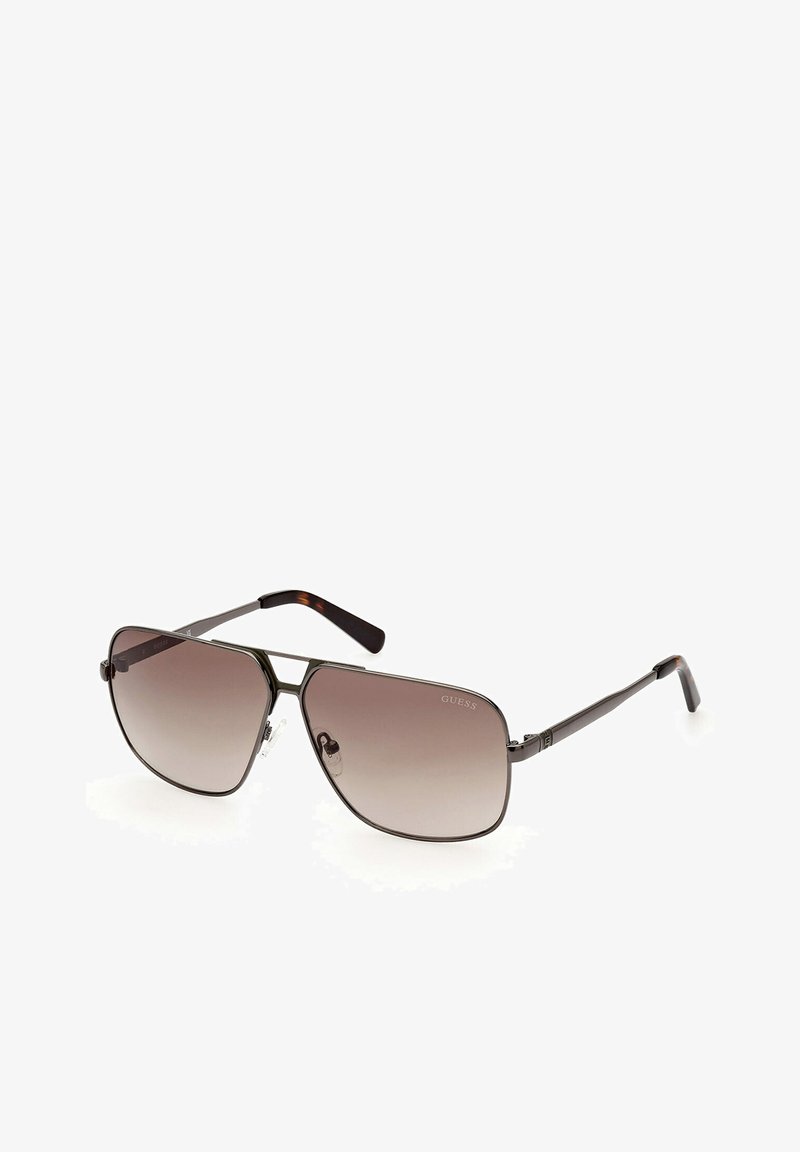 Occhiali da sole stile aviator con lenti sfumate marroni, montatura in metallo di tonalità scura e dettagli in tartaruga sulle tempie. Notare che i naselli sono regolabili.