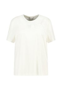 T-shirt blanc à manches courtes en tissu doux, présentant un motif floral en tissu texturé blanc sur l'épaule gauche. Encolure ronde.