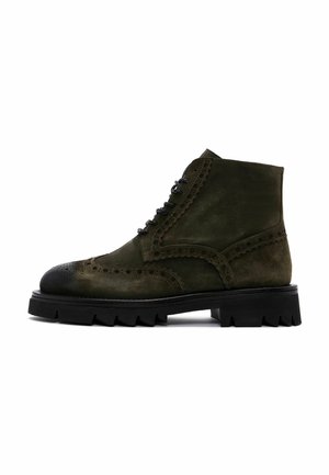 Botín de cuero verde oliva hasta el tobillo con puntera redondeada, detalles de brogue y suela de goma texturizada en negro. Cuenta con cordones en la parte delantera y punta reforzada.