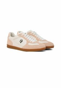 Paire de baskets basses beige et blanches avec lacets blancs, semelles en gomme et un petit logo tête de mort noir et blanc sur les côtés.
