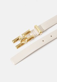 Cintura in pelle bianca con fibbia geometrica dorata con accenti rettangolari e texture liscia. Regolabile con più fori.