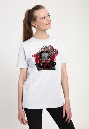 Biała bawełniana koszulka z grafiką czaszki z czerwonymi skrzydłami nietoperza i czarnymi zawijasami, nadrukowana w mieszance czerwonego i czarnego atramentu.