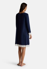 Longue notte blu navy con maniche lunghe e bordo in pizzo bianco scallopato all'orlo e alle maniche, realizzata in un tessuto morbido e liscio.