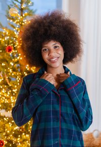 Pyjama en flanelle à carreaux verts foncés et bleus avec des accents rouges; modèle boutonné et coupe décontractée. Texture douce avec manches longues.