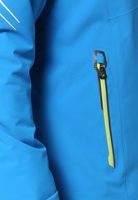 Manche et torse de veste bleu vif avec une poche zippée verticale jaune bordée de noir sur le côté droit.
