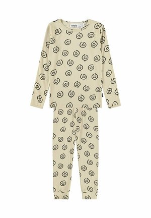 Conjunto beige de camiseta de manga larga y pantalones con patrón de caritas sonrientes dibujadas a mano en negro y puños elásticos en los pantalones.