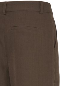 Pantalon marron sur mesure avec passants de ceinture et une seule poche arrière à passepoil, vu de dos au niveau de la taille et des hanches.