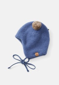 Chapeau en laine bleu pour bébé avec un pompon marron sur le dessus et des attaches au menton, posé à plat sur un fond blanc.