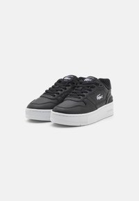 Sneakers in pelle nera con colletto imbottito, suola in gomma bianca e design con lacci; presenta un logo sulla linguetta e sul pannello laterale.