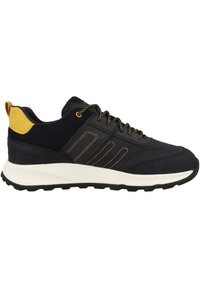 Zapatillas deportivas negras con un upper de tela texturizada, acentos amarillos y cordones negros. Presentan un diseño de tres rayas y suela blanca.
