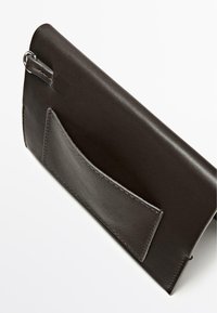 Pochette in pelle marrone con texture liscia, dotata di una tasca frontale e di un anello per l'attacco. Design strutturato con cuciture ordinate.