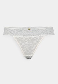 Witte kanten string met bloemenpatronen, voorzien van een doorzichtige kanten tailleband en satijnen accenten. Gouden hardware detail aan de voorkant.