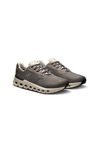 Lekkie buty biegowe w szarym siateczkowym materiale z amortyzującą podeszwą, posiadające duże wycięcia, czarne akcenty i sznurowaną konstrukcję.