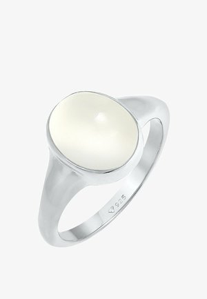 Anello in argento sterling con un centro in pietra ovale bianca liscia e lucida, accompagnato da una fascia svasata.