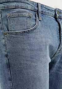 Jasnoniebieskie dżinsy z klasycznym pięciopocketowym wzornictwem. Posiadają prosty krój, widoczne szwy i lekko wypłowiały wygląd.