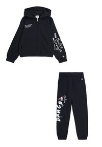 Felpa nera con zip e cappuccio, caratterizzata da stampe grafiche sulle maniche. Pantaloni da tuta neri abbinati con la scritta "DANCE". Entrambi in un tessuto morbido.