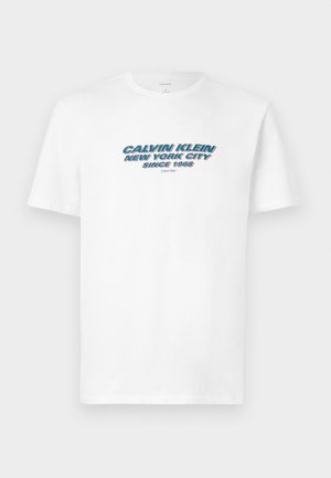 Bijela pamučna majica s grafičkim otiskom na kojem piše "CALVIN KLEIN NEW YORK CITY SINCE 1968" u plavom i crvenom stiliziranom tekstu.