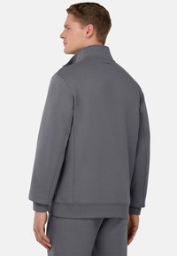 Veste à pull grise en tissu doux, dotée d'un col montant, de poignets côtelés et d'une coupe décontractée. Design minimaliste sans motifs visibles.