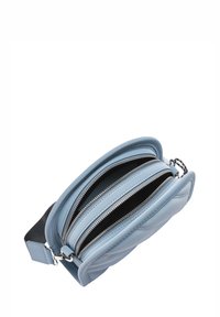 Jasnoniebieska skórzana torba z dwoma zapinanymi na suwak przegrodami, zaokrąglonymi krawędziami i czarną podszewką z tkaniny. Wyposażona w srebrne elementy metalowe i regulowany pasek.