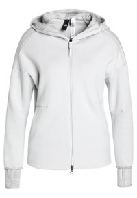 Sudadera blanca con cremallera y capucha, hecha de una tela suave. Cuenta con grandes bolsillos, puños acanalados y un forro interior texturizado. Diseño sencillo.