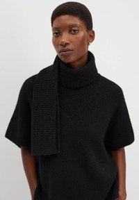 Maglione nero lavorato a maglia con collo alto e maniche corte, caratterizzato da una texture a coste e una sciarpa abbinata appoggiata sulla spalla.