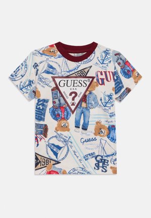 Bela srajca s kratkimi rokavi in bordo ovratnikom, okrašena z medvedki v kavbojkah, pomorskimi motivi in velikim osrednjim trikotnim logotipom Guess.